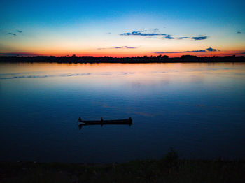 Scenic view of lake against sky at sunset