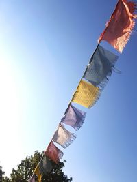 Low angle view of colorful prayer flags against clear sky