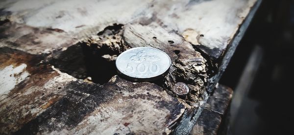 High angle view of coins on wood