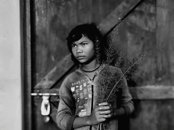 Portrait of young woman looking away against wall