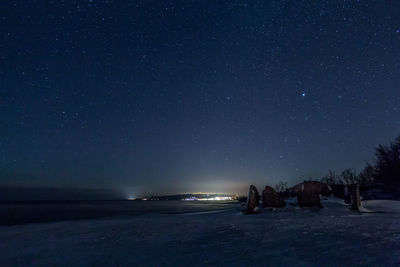 Idyllic shot of snow covered landscape against sky at night