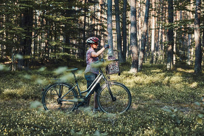 Active woman spending free vacation time on a bicycle trip in a forest on sunny summer day