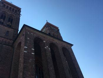 Low angle view of historic building against clear blue sky