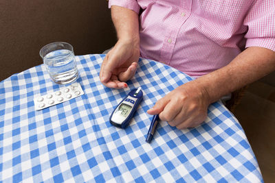 Midsection of man holding hands on table