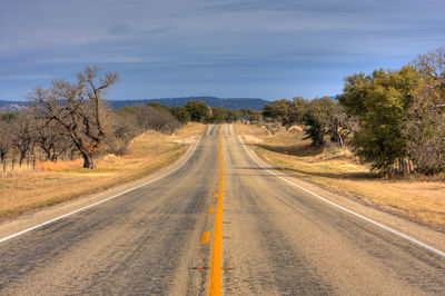 Empty road on field against sky