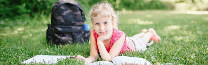 Rear view of girl sitting on field
