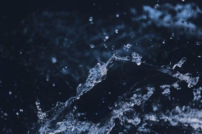 Close-up of water splashing against black background