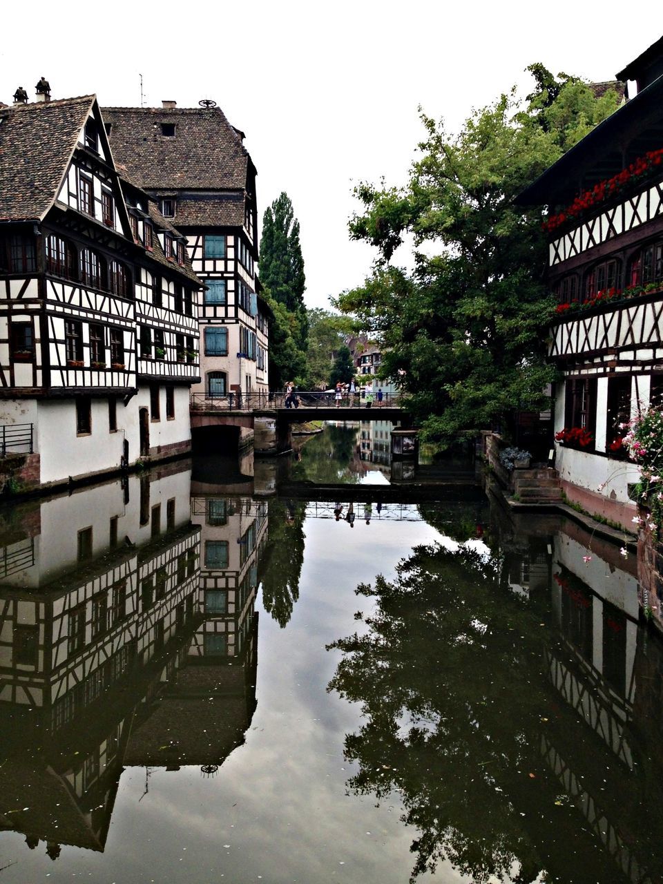 building exterior, architecture, built structure, water, reflection, tree, canal, waterfront, house, residential building, residential structure, sky, river, standing water, clear sky, building, city, day, outdoors, lake