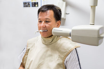 Mature man examined by dental equipment