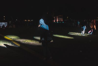 People walking on illuminated street at night