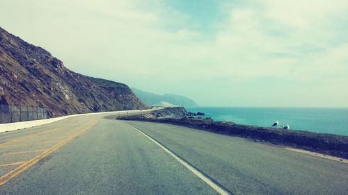 Empty road leading towards sea