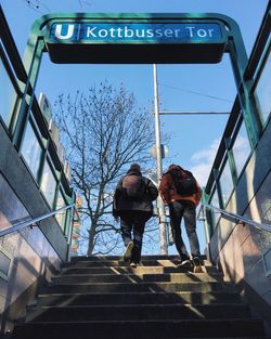 Low angle view of people moving up on staircase at subway station