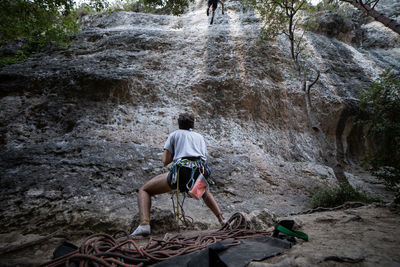 Rear view of men climbing rock
