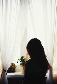 Woman looking through window