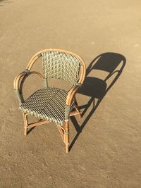Close-up of chair on sandy ground at late afternoon 