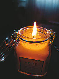 Close-up of lit candle in glass