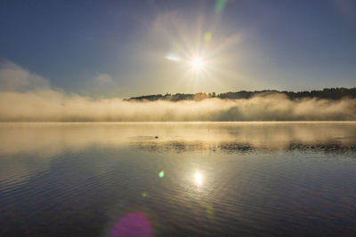 Scenic view of lake against sky on sunny day