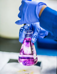 Cropped image of person holding flask in laboratory person