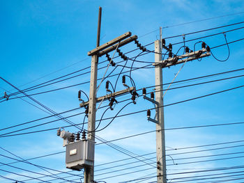 Low angle view of electricity pylons against sky