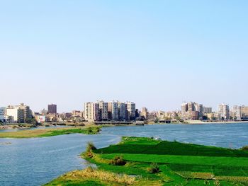 Buildings in city against clear sky