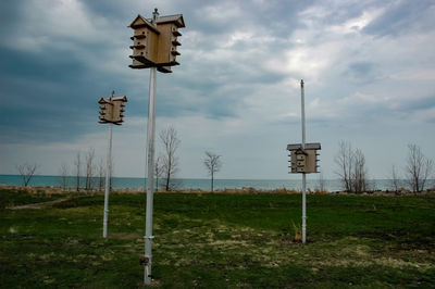 Wooden post on field against sky