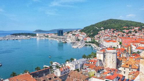 High angle view of townscape by sea against sky