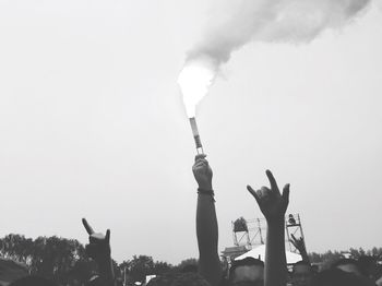 Cropped image of hand holding distress flare during festival