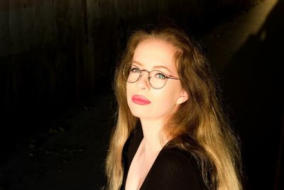 Close-up portrait of beautiful woman against black background