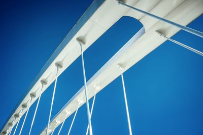 Low angle view of suspension bridge against clear blue sky