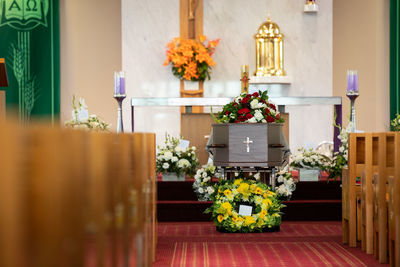 Closeup shot of a funeral casket or coffin in a hearse or chapel or burial at cemetery
