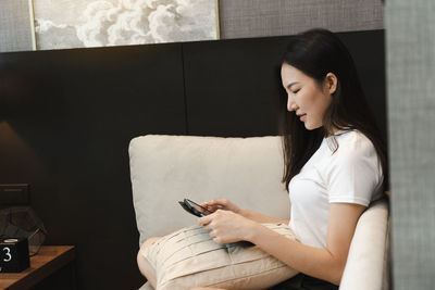 Young woman using mobile phone at home