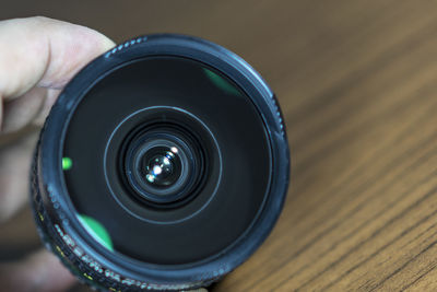 High angle view of person holding camera on table