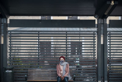 Woman with face mask waiting for public transportation