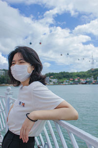 Woman looking at camera against sky