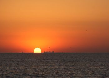 Scenic view of sea against orange sky