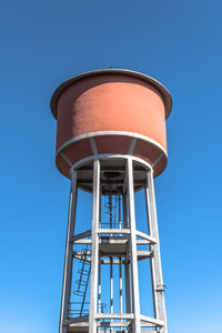 Low angle view of water tower against blue sky