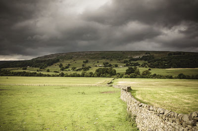 Scenic view of field against cloudy sky