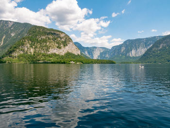 Scenic view of lake by mountains against sky