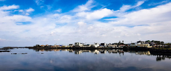 Scenic view of lake by buildings against sky