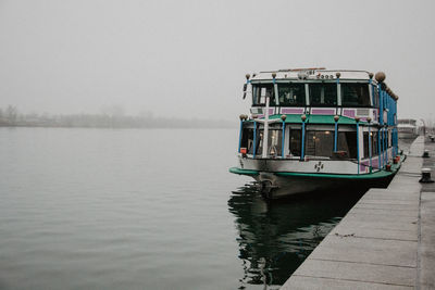 Boat moored on lake against sky