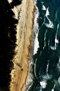 Directly above shot of waves rushing on shore at beach