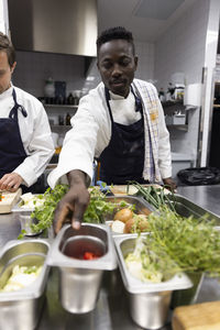 Chefs preparing food in kitchen of restaurant