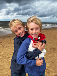 Portrait of happy friends standing at beach