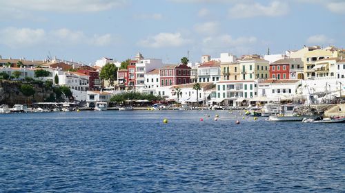 Buildings by sea against sky in city