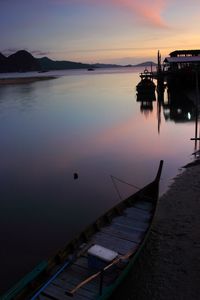 Boat moored on sea against sky during sunset