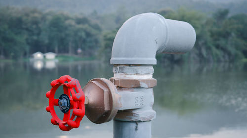 Close-up of coin-operated binoculars by lake