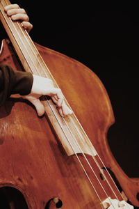 Low angle view of hands playing piano against black background