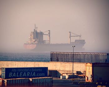 Commercial dock by sea against sky