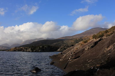 Scenic view of sea and mountains against sky