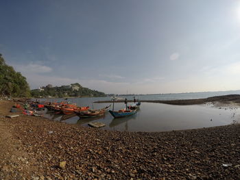 Boats moored on beach against sky